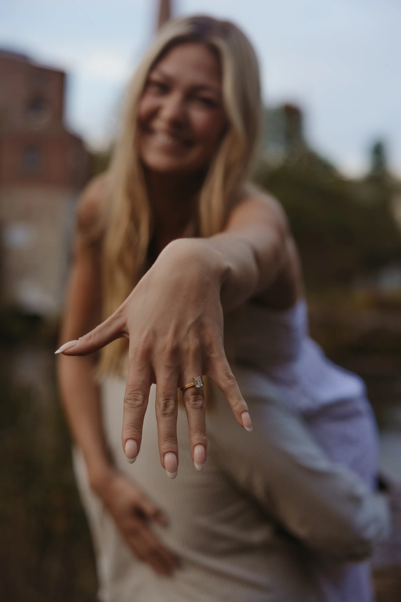 Woman showing off engagement ring with blurred background
