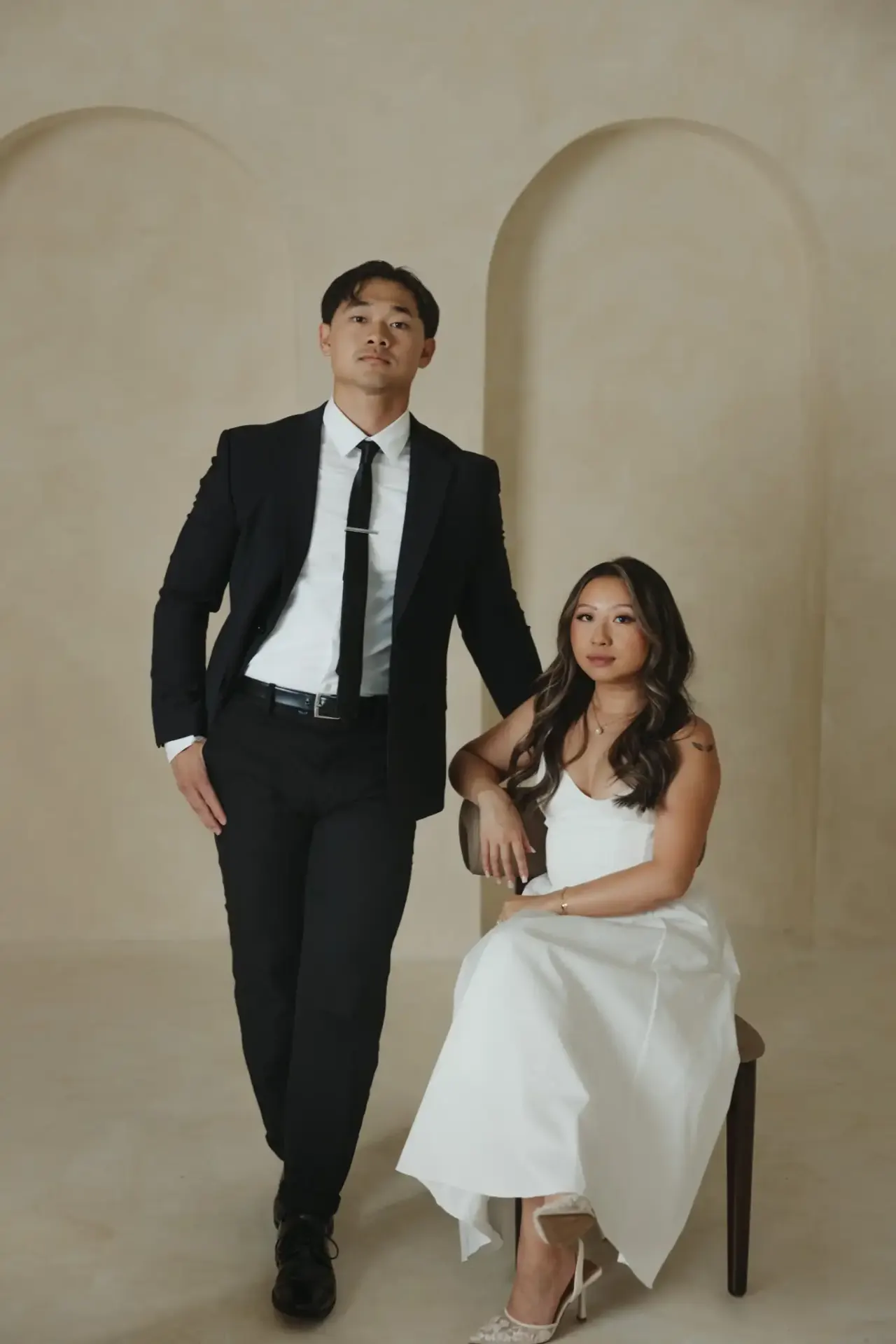 Groom standing beside his seated bride in a studio with arched alcoves — Minneapolis & Twin Cities wedding photography by Emma Ziegler, Honey Deww Photography (Minnesota)