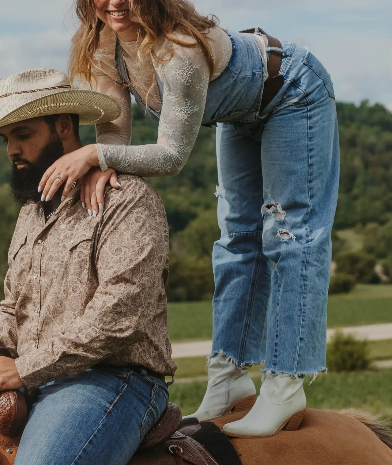 Hand resting on a rider's shoulder as his partner stands on the saddle behind him — Minneapolis & Twin Cities wedding photography by Emma Ziegler, Honey Deww Photography (Minnesota)