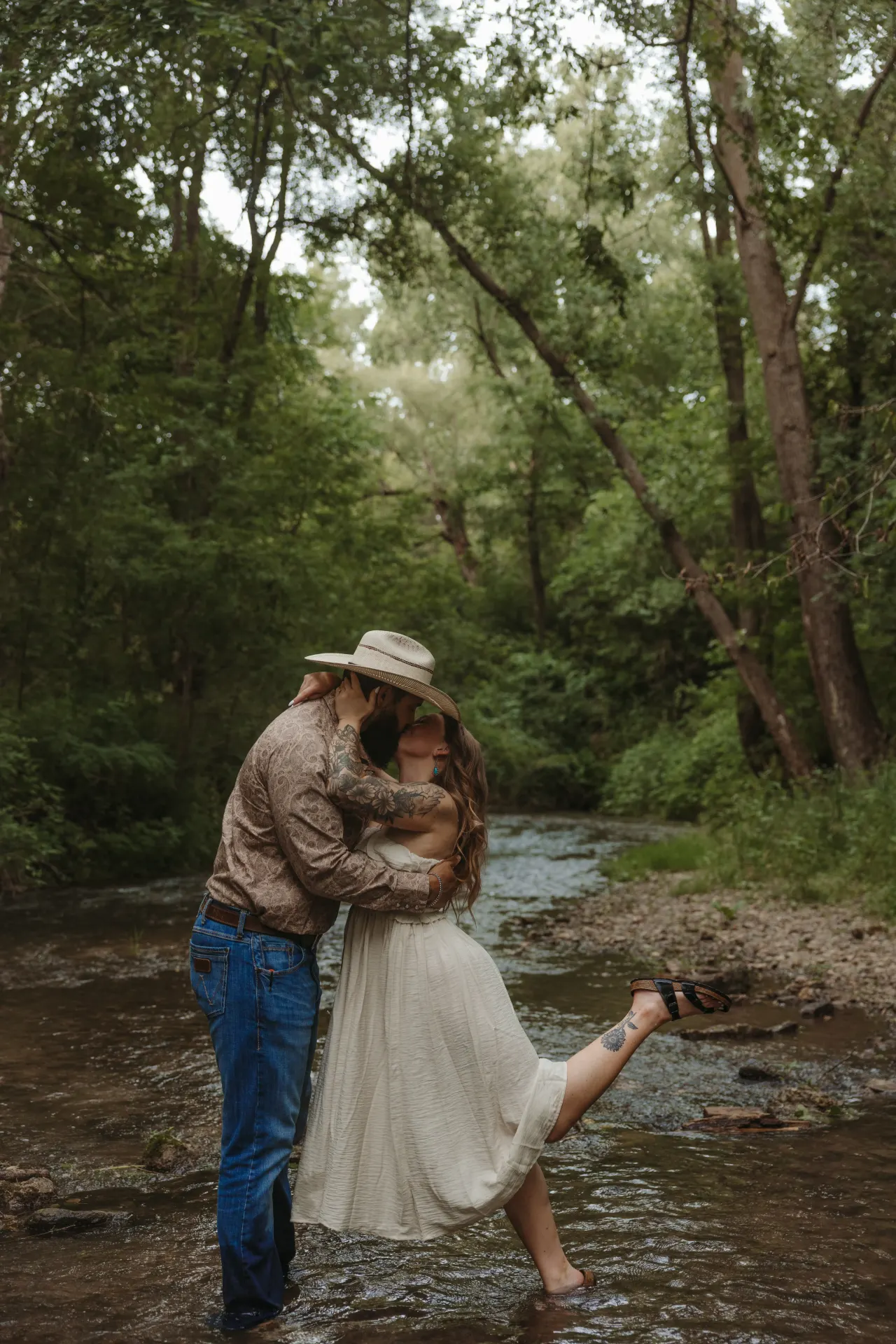 Couple embracing barefoot in a shallow creek surrounded by summer woods — Minneapolis & Twin Cities wedding photography by Emma Ziegler, Honey Deww Photography (Minnesota)