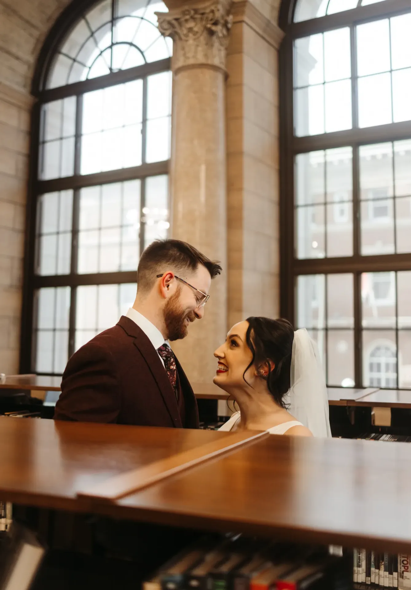 Bride and groom laughing at piano in grand hall