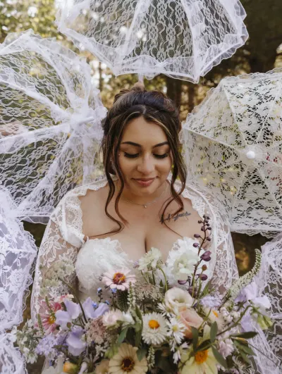 Bride with wildflower bouquet surrounded by lace parasols — Tonka Bay, Minnesota wedding photography by Emma Ziegler, Honey Deww Photography