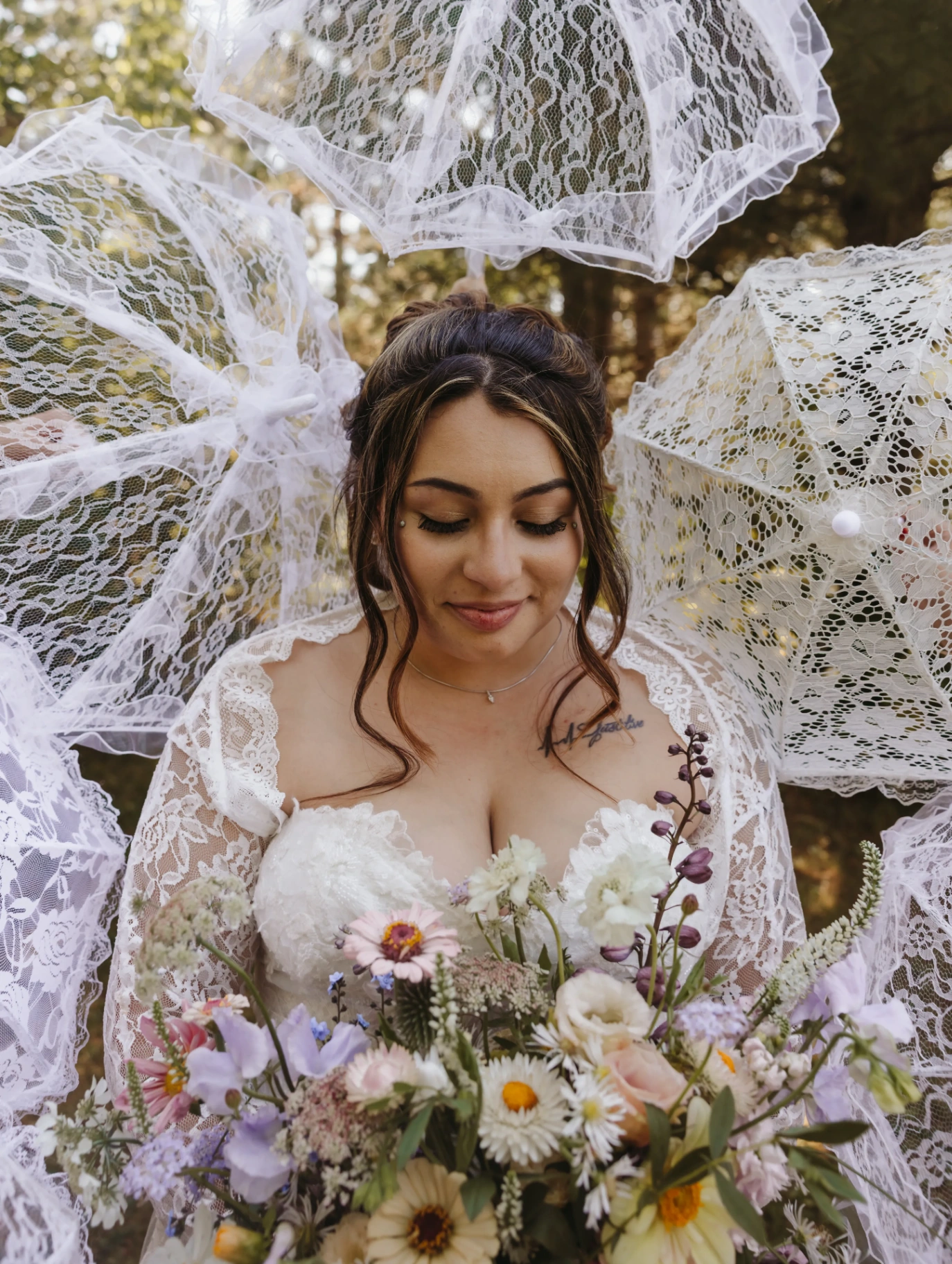 Bride with wildflower bouquet surrounded by lace parasols