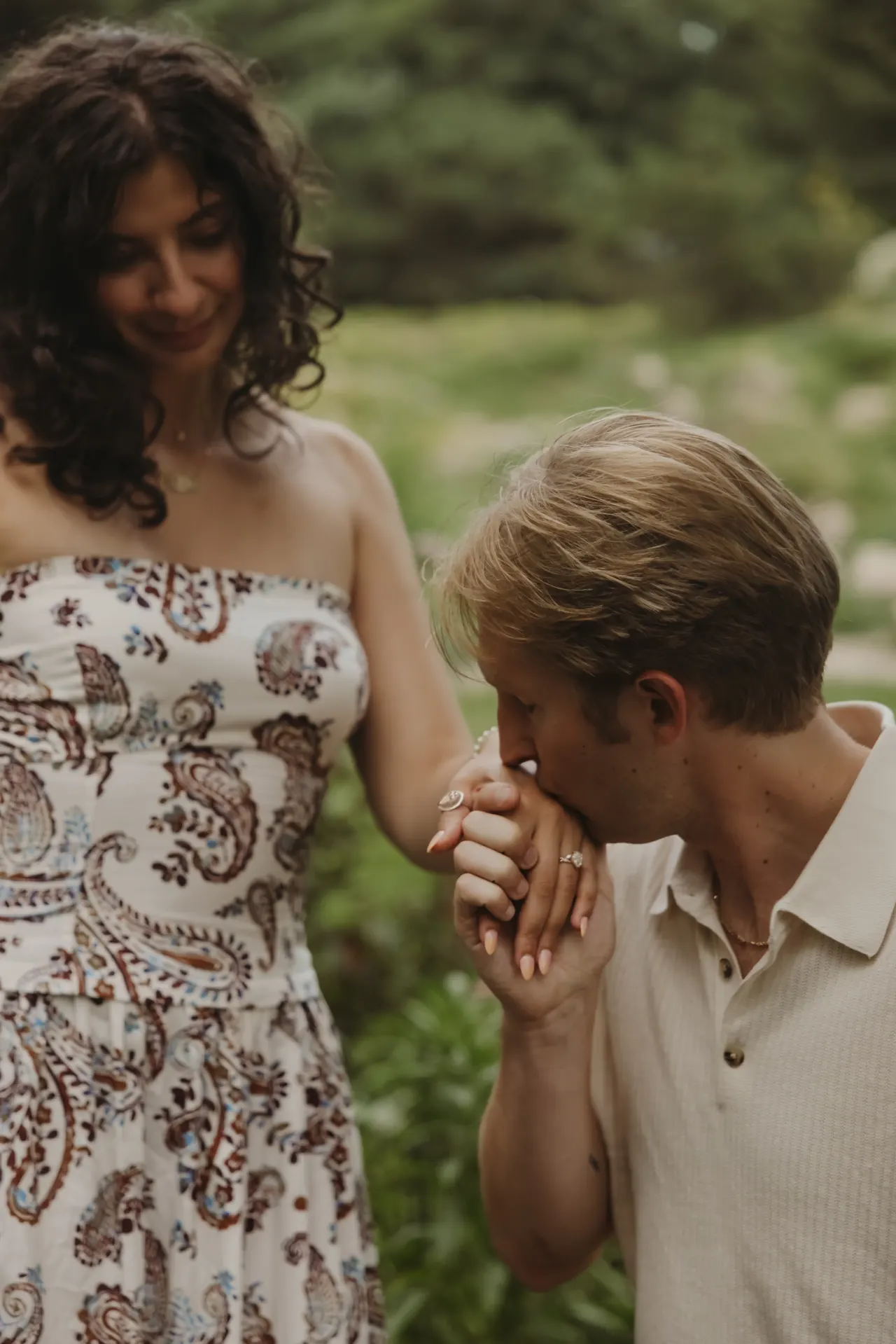 One partner bowing to kiss the other's hand on a wooded path — Minneapolis & Twin Cities wedding photography by Emma Ziegler, Honey Deww Photography (Minnesota)