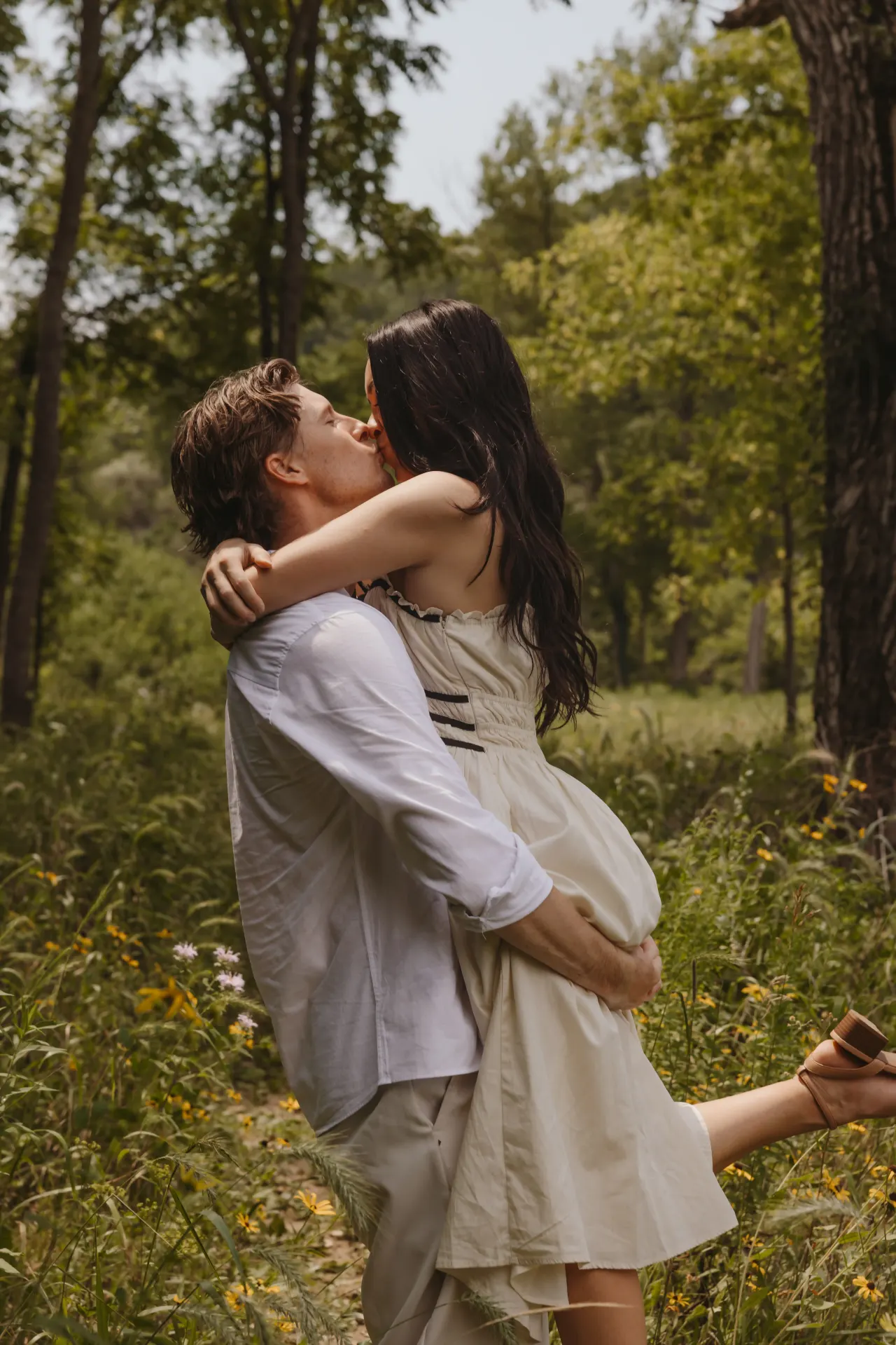 Groom lifting his bride off her feet for a kiss in a wildflower meadow — Minneapolis & Twin Cities wedding photography by Emma Ziegler, Honey Deww Photography (Minnesota)