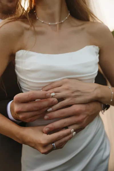 Close-up of wedding rings on bride's hands against white dress — St. Cloud, Minnesota wedding photography by Emma Ziegler, Honey Deww Photography