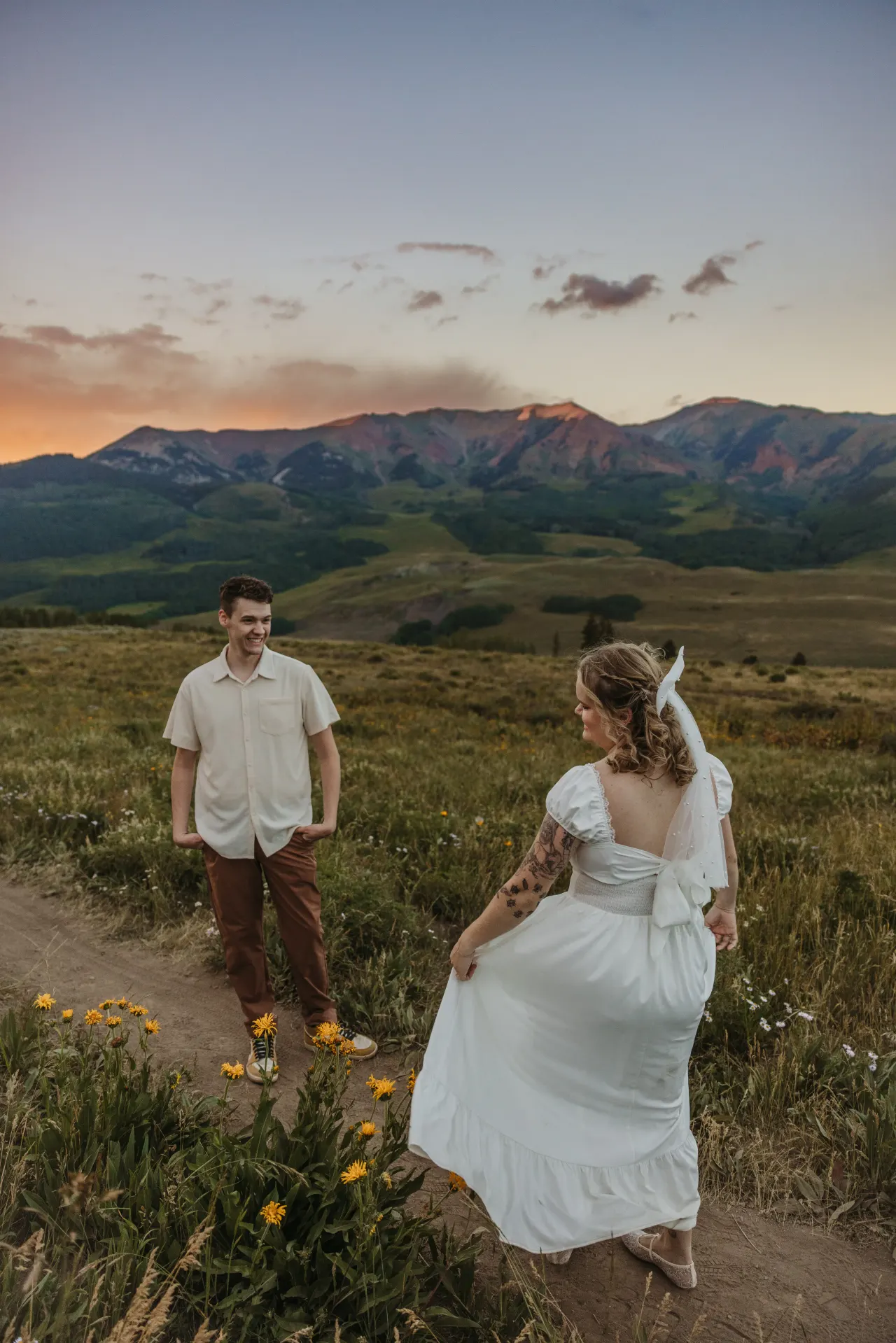 Bride turning back toward her groom on a mountain path in the evening light — Minneapolis & Twin Cities wedding photography by Emma Ziegler, Honey Deww Photography (Minnesota)