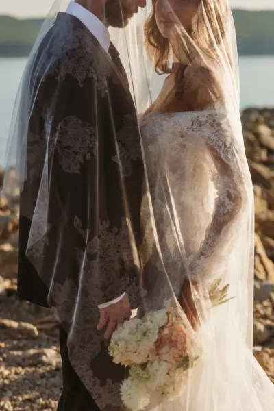 Bride and groom behind lace veil with bouquet on rocky lakeshore — Hammond, Minnesota wedding photography by Emma Ziegler, Honey Deww Photography