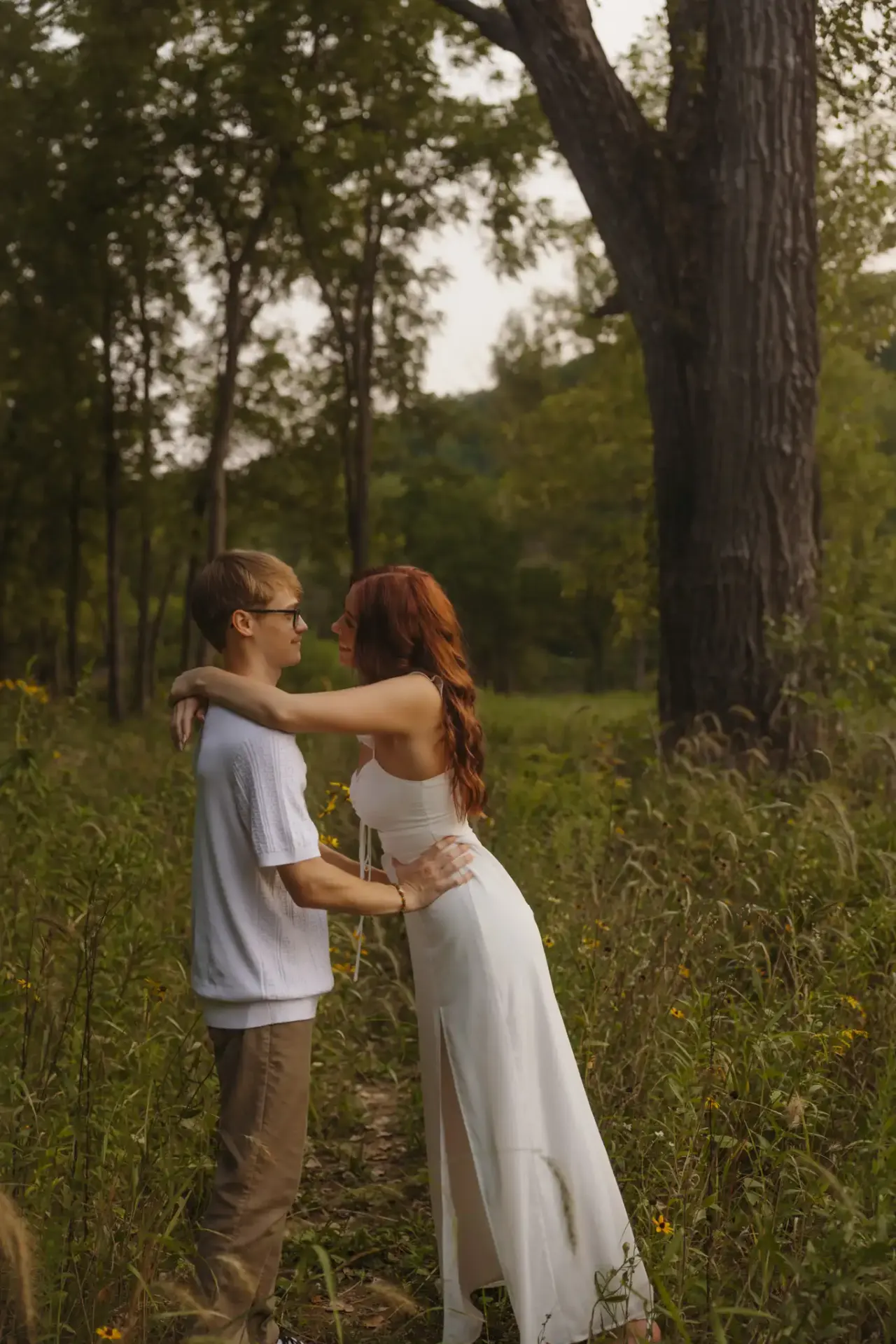 Couple embracing in a summer meadow, her white dress catching the light — Minneapolis & Twin Cities wedding photography by Emma Ziegler, Honey Deww Photography (Minnesota)