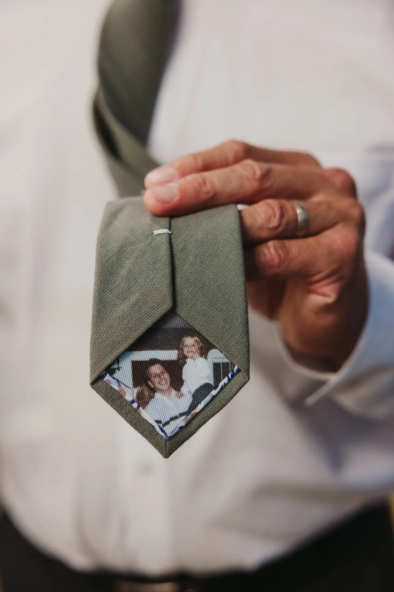 Groom holding out his tie to show a photograph sewn inside as a memorial — Minneapolis & Twin Cities wedding photography by Emma Ziegler, Honey Deww Photography (Minnesota)