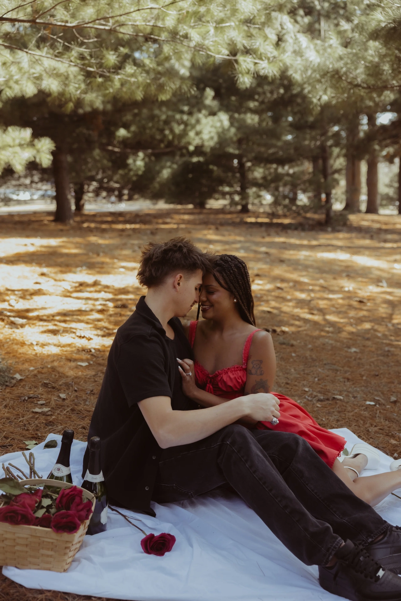 Couple on picnic blanket with roses and champagne under pine trees — Twin Cities couples & engagement photographer Emma Ziegler, Honeydew Photography (Minneapolis, Minnesota)