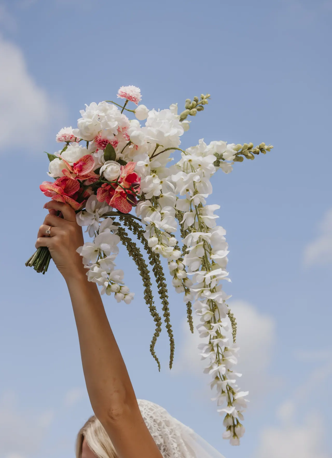 Bride raising a white and coral bouquet against a clear blue sky — Minneapolis & Twin Cities wedding photography by Emma Ziegler, Honey Deww Photography (Minnesota)