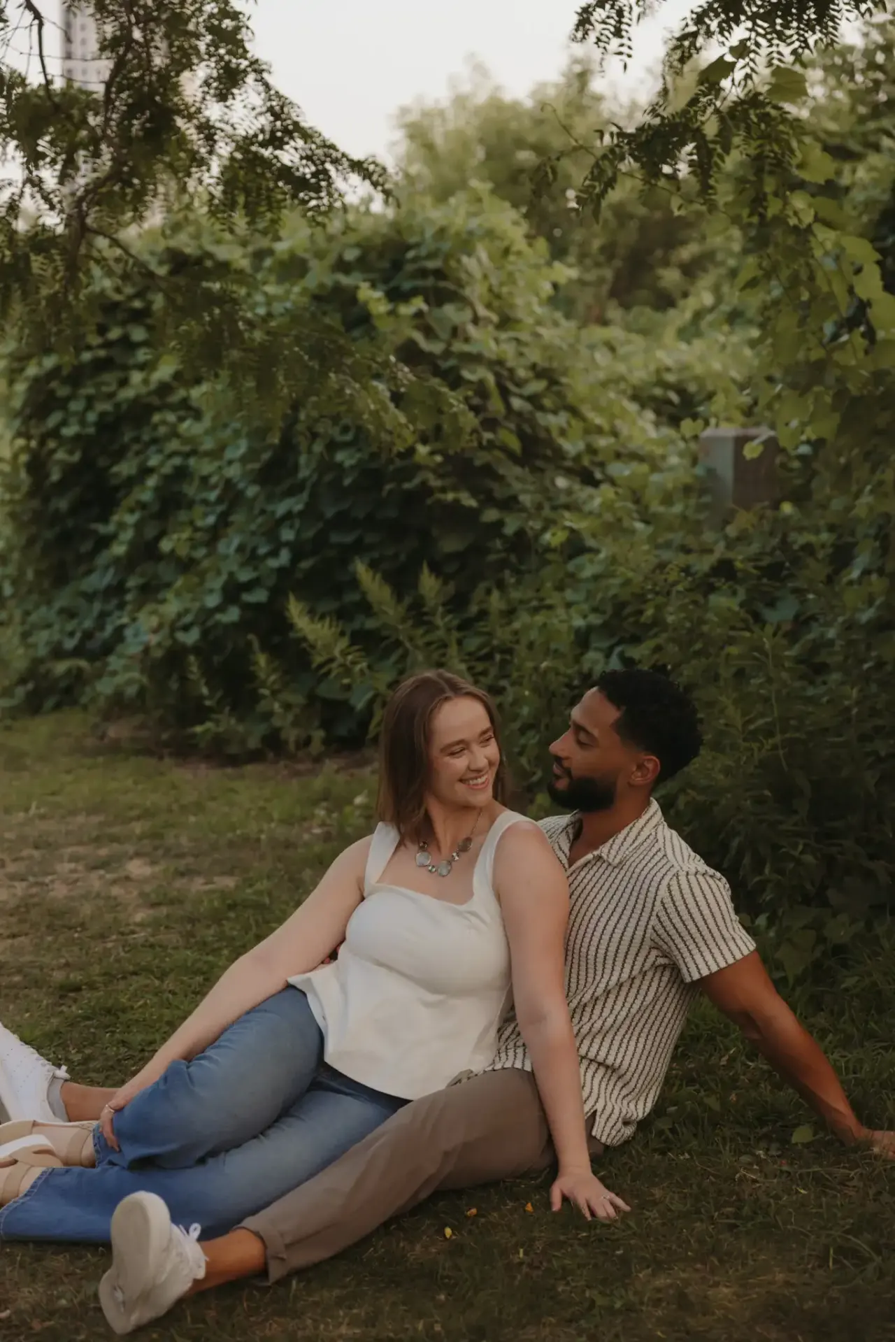 Couple sitting side by side on a lawn in front of a green hedge — Minneapolis & Twin Cities wedding photography by Emma Ziegler, Honey Deww Photography (Minnesota)