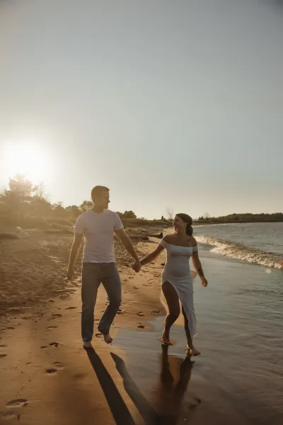 Couple walking hand in hand along beach at golden hour — Maple Plain, Minnesota wedding photography by Emma Ziegler, Honey Deww Photography