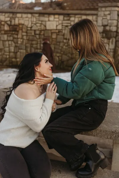 Two women on stone steps with tender face touch at golden hour — Como Park Conservatory, Minnesota wedding photography by Emma Ziegler, Honey Deww Photography