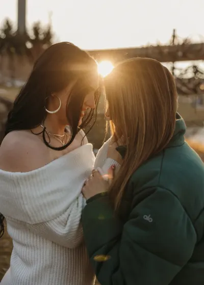 Two women touching foreheads with sun flare between them — Como Park Conservatory, Minnesota wedding photography by Emma Ziegler, Honey Deww Photography