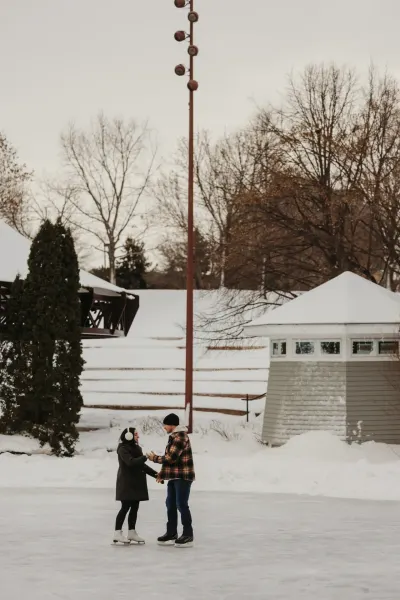 Couple ice skating together at outdoor winter rink — St. Anthony, Minnesota wedding photography by Emma Ziegler, Honey Deww Photography
