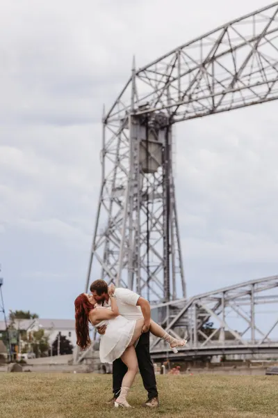 Couple kissing in front of Duluth aerial lift bridge — St. Anthony, Minnesota wedding photography by Emma Ziegler, Honey Deww Photography