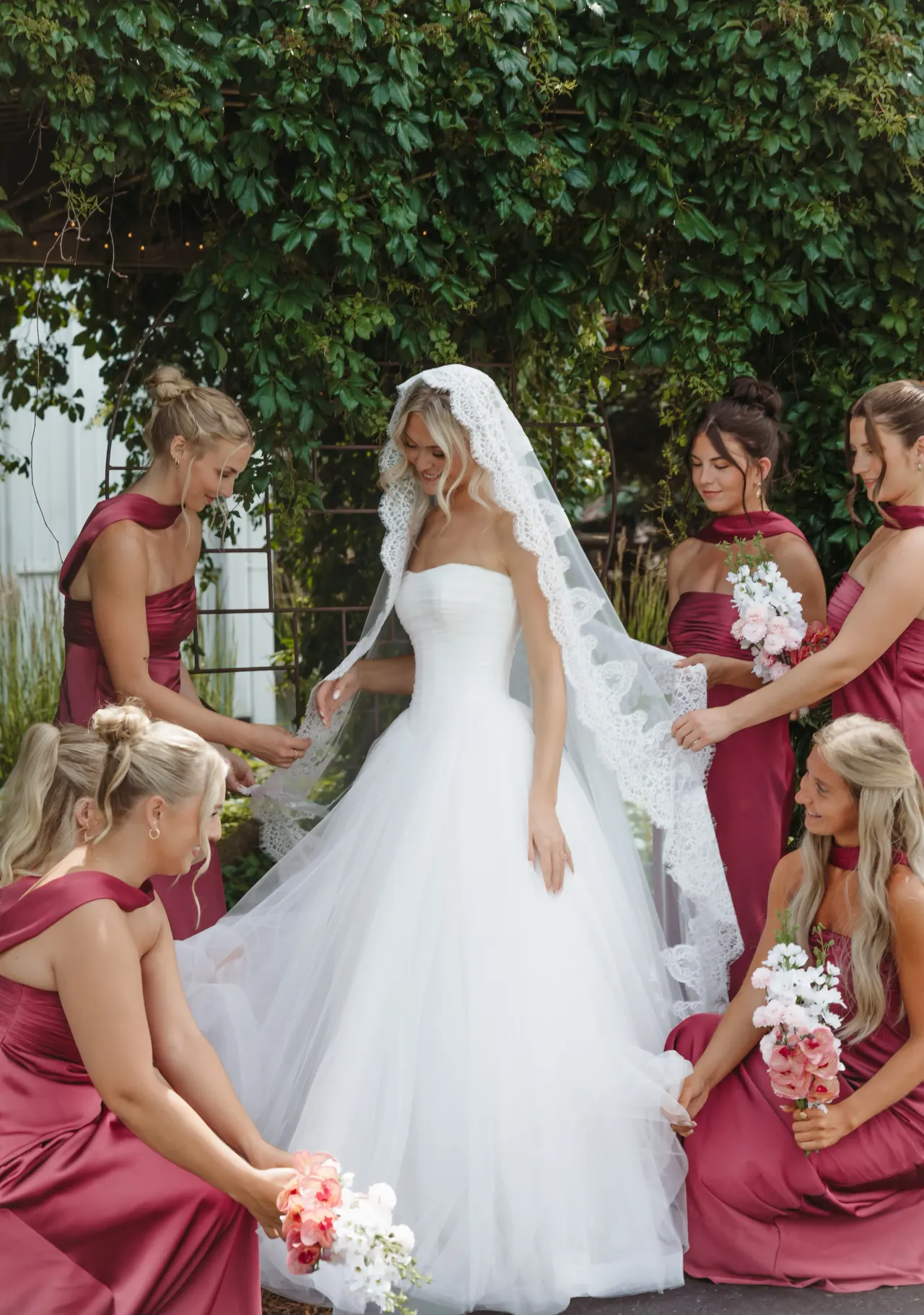 Bridesmaids in berry gowns arranging the bride's cathedral veil — Minneapolis & Twin Cities wedding photography by Emma Ziegler, Honey Deww Photography (Minnesota)