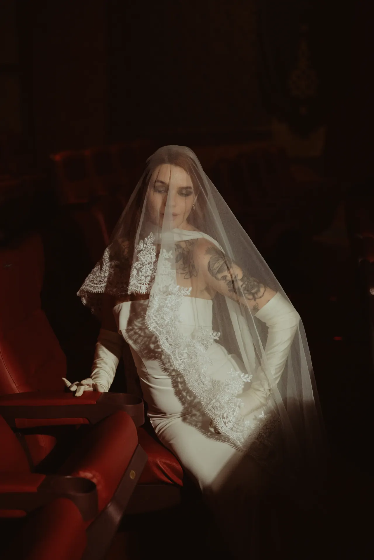 Bride seated under her veil in the low light of an empty theatre — Minneapolis & Twin Cities wedding photography by Emma Ziegler, Honey Deww Photography (Minnesota)