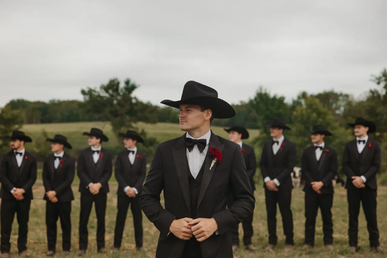Groom in a black hat standing before his groomsmen in an open field — Minneapolis & Twin Cities wedding photography by Emma Ziegler, Honey Deww Photography (Minnesota)