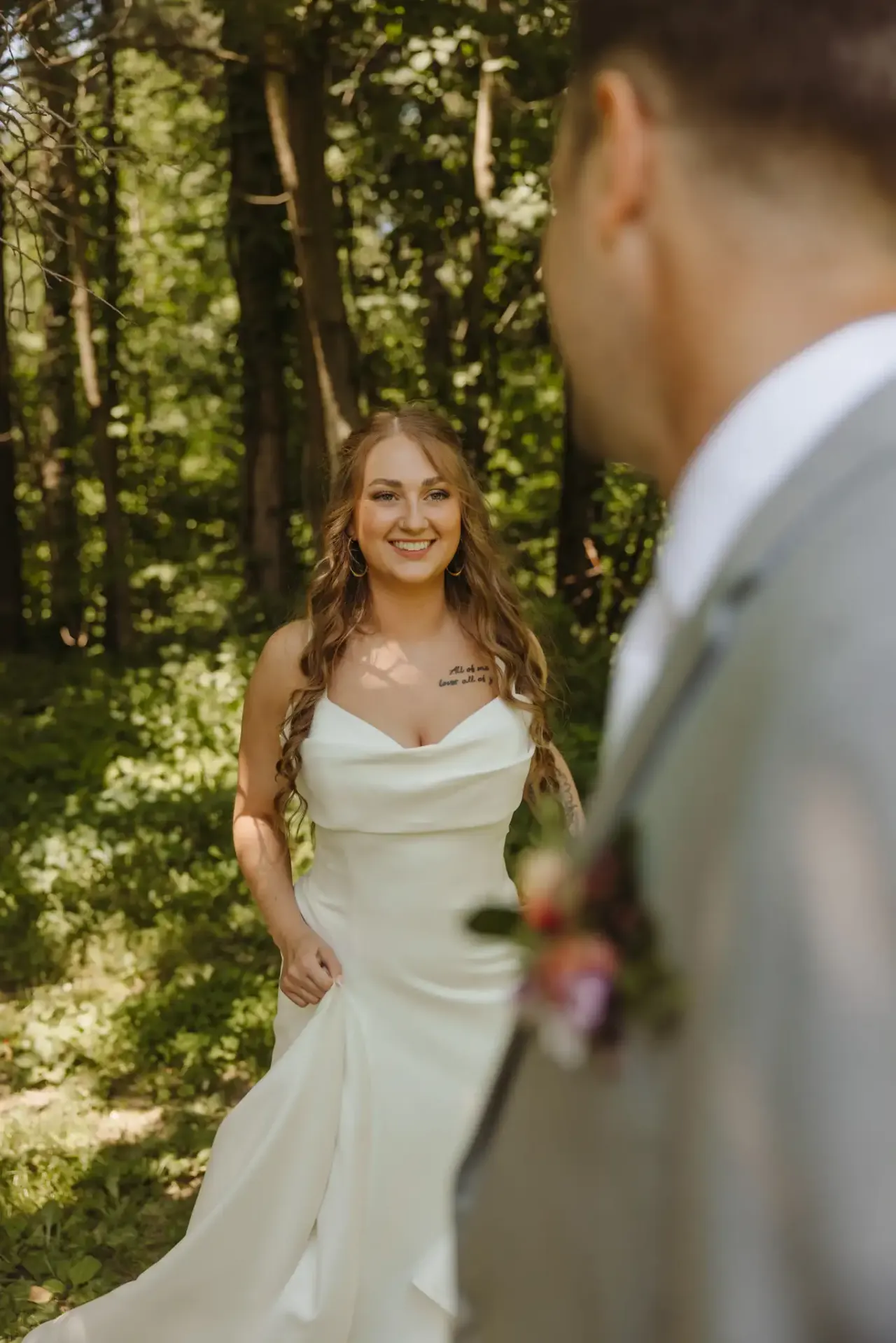 Bride smiling toward her groom in a sunlit clearing during their first look — Minneapolis & Twin Cities wedding photography by Emma Ziegler, Honey Deww Photography (Minnesota)