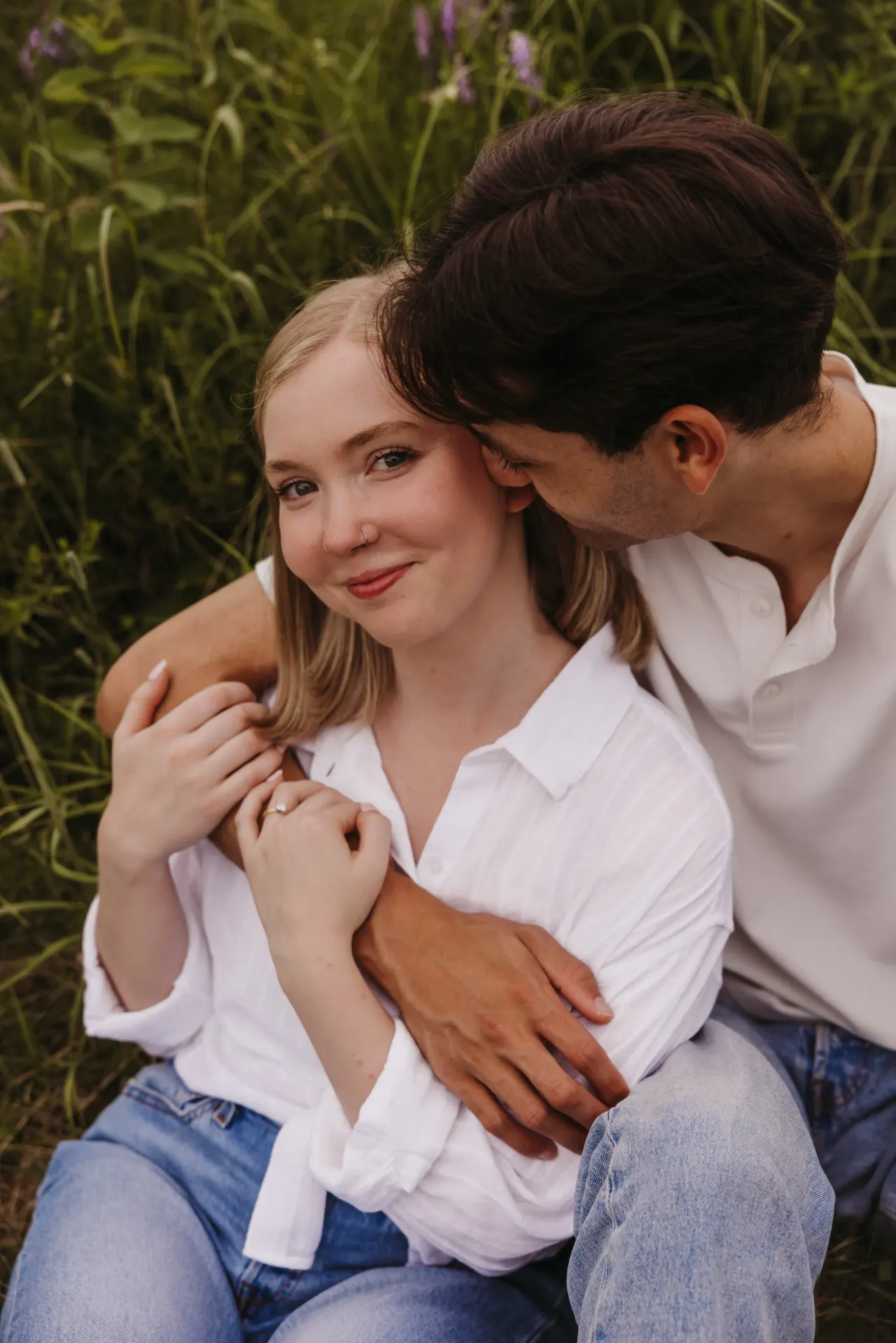 Couple sitting close in tall grass, his arms wrapped around her — Minneapolis & Twin Cities wedding photography by Emma Ziegler, Honey Deww Photography (Minnesota)