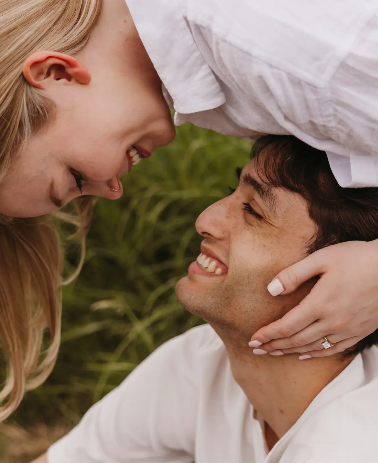 One partner leaning over the other, both laughing, in a summer field — Minneapolis & Twin Cities wedding photography by Emma Ziegler, Honey Deww Photography (Minnesota)