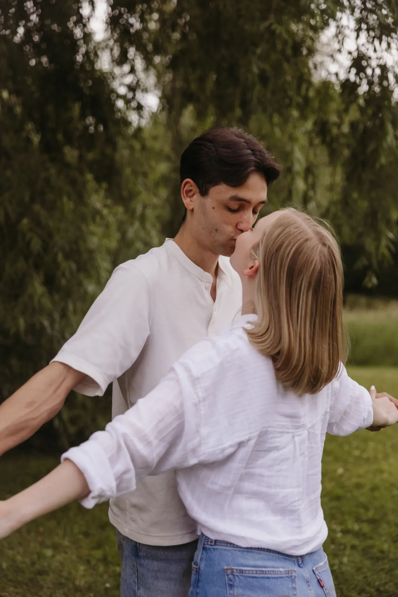 Couple kissing with their arms flung wide in a green park — Minneapolis & Twin Cities wedding photography by Emma Ziegler, Honey Deww Photography (Minnesota)