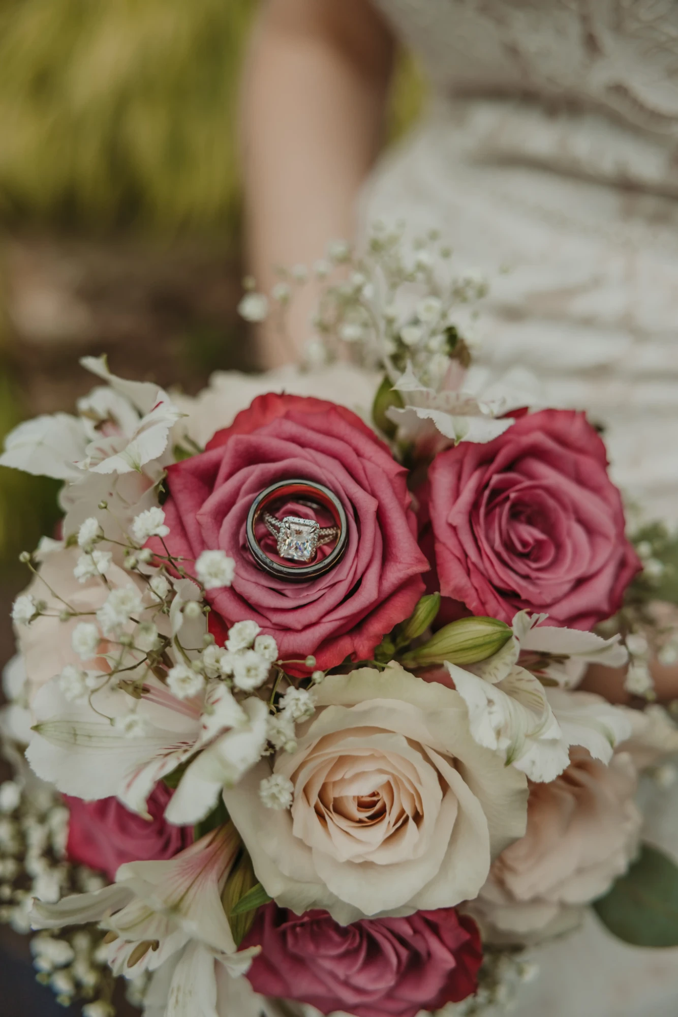Wedding rings resting in a pink rose of the bridal bouquet