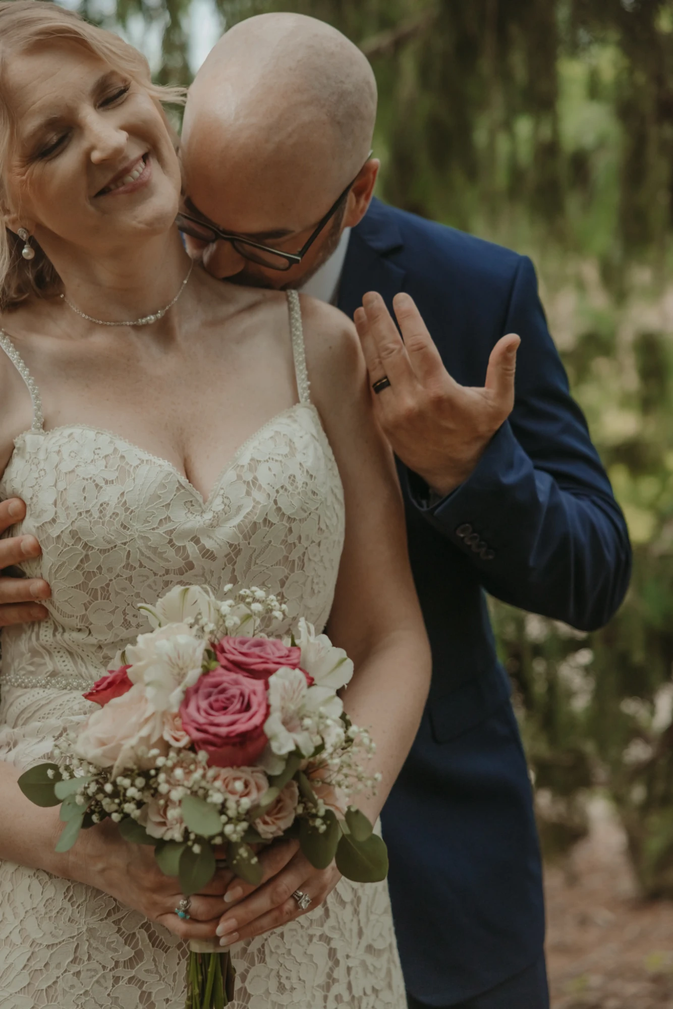 Groom kissing the bride's neck, his wedding band showing